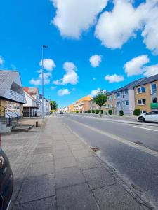 イェリングにあるGrand Luxury Apartment In The Center Of Hjoerringの家々が並ぶ空っぽの通りと雲が浮かぶ青い空