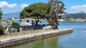 a house on the side of a lake with a tree at BELLA VILLA TRA MARE e LAGO in Sperlonga