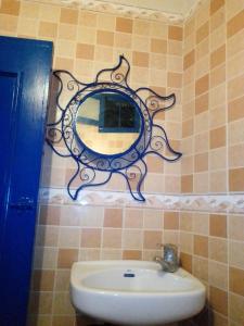 ein Spiegel an einer gefliesten Wand über einem Waschbecken in der Unterkunft Studio duplex pierre bleue in Asilah + 19 Fotos