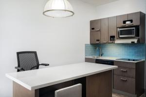 a kitchen with a white counter top and a sink at Hyatt House Naples 5th Avenue in Naples