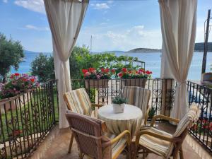 a table and chairs on a balcony with a view of the ocean at Vila DORA - Studio Dora in Martinšćica