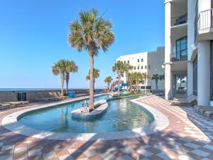 a swimming pool with a palm tree in the middle at Phoenix West II #1407 in Orange Beach
