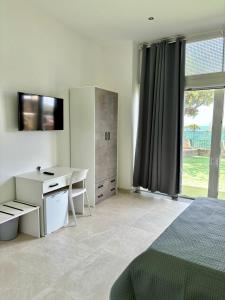 a bedroom with a bed and a desk and a window at Casa Francesca in Marina di Camerota