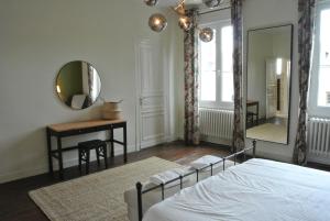 Un dormitorio con una cama, un espejo y una mesa. en Nor14 - Vire - Maison Bear, en Landelles-et-Coupigny
