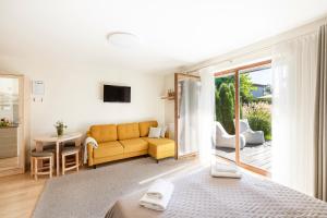 a bedroom with a couch and a living room at Vila Epušė in Palanga