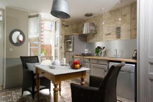 une cuisine avec une table et des chaises dans l'établissement Appartements du Port, à Port-en-Bessin-Huppain