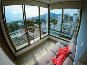 a living room with a couch in front of a window at Santorini Apartamentos Amoblados in Pereira