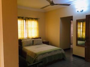 a bedroom with a bed and a ceiling fan at Single Room With Balcony in Accra