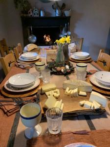 a table with cheese and plates and a fireplace at Affittacamere Montagne Verdi in Varallo