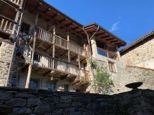 a building with wooden balconies on the side of it at Affittacamere Montagne Verdi in Varallo +23 photos