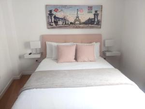 a bedroom with a bed with pink and white pillows at Agradable casa con terraza in Las Lagunas