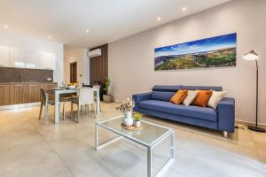 a living room with a blue couch and a table at FL 2 TheLODGE-Charming City Retreat by Homely in Mellieħa