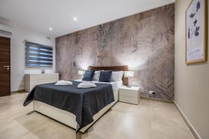 una camera da letto con un letto grande con cuscini blu di Fl 2 Thelodge-charming City Retreat By Homely a Mellieħa