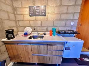 a small kitchen with a sink and a stove at Apto Studio Industrial 07 in Manaus