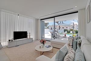 a living room with a couch and a tv at One Six Villa in Vilamoura