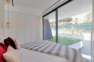 a bedroom with a bed and a large window at One Six Villa in Vilamoura +44 photos
