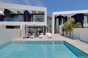 an external view of a villa with a swimming pool at One Six Villa in Vilamoura