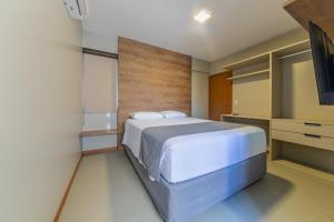 a bedroom with a bed and a flat screen tv at Top Unique Maceió in Maceió