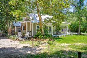 a house with a tree in the yard at Historic Biloxi Bay Cottage with Beautiful View in Ocean Springs