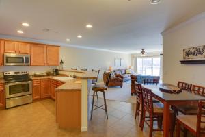 a kitchen and living room with a table and chairs at Lake Views and Pool Access Osage Beach Condo in Osage Beach