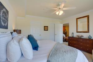 a bedroom with a bed with pillows and a ceiling fan at Lake Views and Pool Access Osage Beach Condo in Osage Beach +19 photos