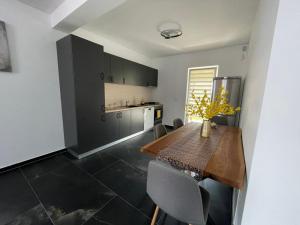 a kitchen with a wooden table and chairs in a room at BIA Twin House in Arad