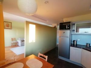 a small kitchen with a table and a refrigerator at Jauki erdvĖ in Vilnius