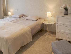 a bedroom with a bed with two tables and a dresser at Külaliskorter Kärdlas in Kärdla