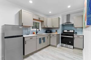 Una cocina con gabinetes blancos y electrodomésticos negros. en Downtown Orlando 1br Peaceful Convenient, en Orlando 9 fotos más