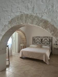 a bedroom with a bed in a stone wall at Agli Antichi Trulli in Alberobello +63 photos