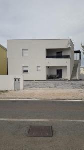 a white building on the side of a street at B&L Apartments in Vir