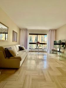 a living room with a couch and a television at Cannes Rue d'Antibes - 2 Minutes walk from Beach, Palais des Festivals, Boulevard de la Croisette - Free Parking - Studio Gray d'Albion in Cannes