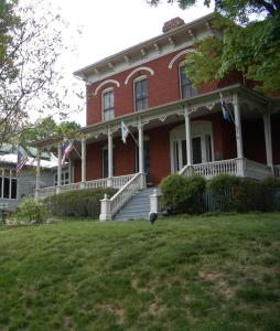 a large red brick house with american flags on it at Ubon Thai Victorian Inn & Restaurant in Staunton