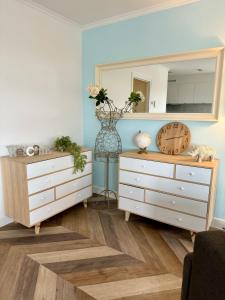ein Wohnzimmer mit einer Kommode und einem Spiegel in der Unterkunft Cozy Panorama Flat by the Beach in Knokke-Heist