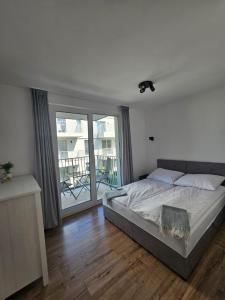 a bedroom with a bed and a large window at Apartament Cuma - zacumuj w Pucku in Puck