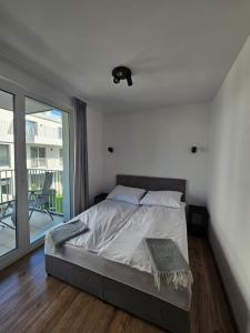 a bedroom with a bed and a large window at Apartament Cuma - zacumuj w Pucku in Puck