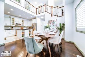 ein Esszimmer mit einem Tisch und weißen Stühlen in der Unterkunft Bright Luxury Home-Hot Tub-Sunroom-King Bed-AC in Edmonton