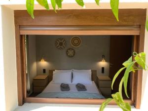 Un dormitorio con una cama con dos almohadas y un espejo. en ILIOS Luxury Apartment, en Nea Iraklitsa