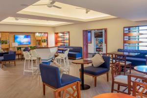 a restaurant with chairs and tables and a bar at Plaza Pelicanos Club Beach Resort All Inclusive in Puerto Vallarta