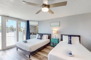 a bedroom with two beds and a ceiling fan at The Top of the Gulf #112 in Panama City Beach
