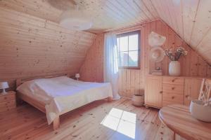 a bedroom with a bed in a wooden house at Mandala Domki in Bobolin