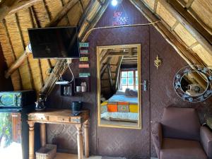 a bedroom with a bed and a mirror in a room at Sweet Melody Tree House in Gaborone