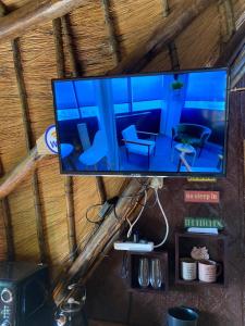 a flat screen tv hanging on a wooden wall at Sweet Melody Tree House in Gaborone +26 photos