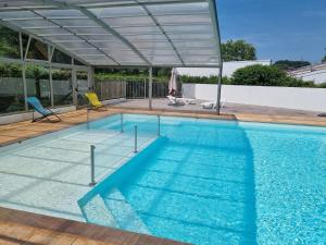 a large swimming pool with a canopy over it at Chalet Etxean in Hasparren