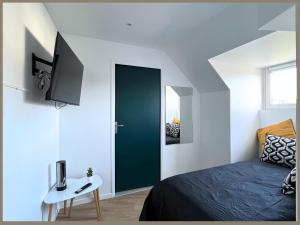 een slaapkamer met een groene deur en een bed en een tafel bij SQ'Appart-y in Saint-Quentin