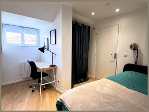 een slaapkamer met een bureau en een bed bij SQ'Appart-y in Saint-Quentin