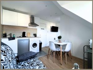 een keuken met een tafel en een wasmachine bij SQ'Appart-y in Saint-Quentin