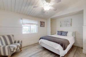 una camera con letto, ventilatore a soffitto e sedia di The Cottage a Temecula