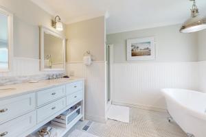 un bagno bianco con lavandino e vasca di The Cottage a Temecula Altre 18 foto