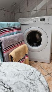 a washing machine with a towel next to a table at Apartament na Gryfa 8 in Stężyca +33 photos